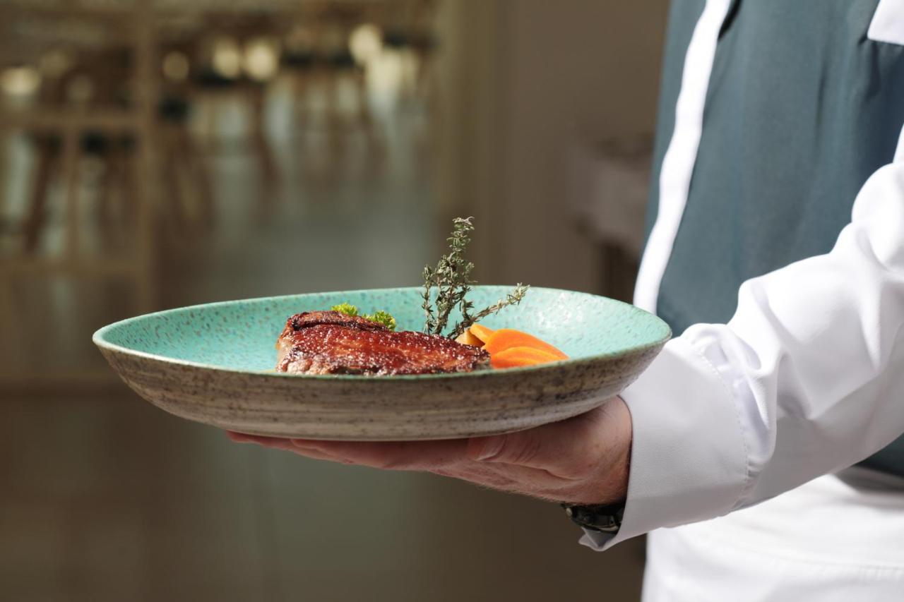 ホテル イベロスター セレクション サビラ アデヘ エクステリア 写真 A waiter holding a plate of food
